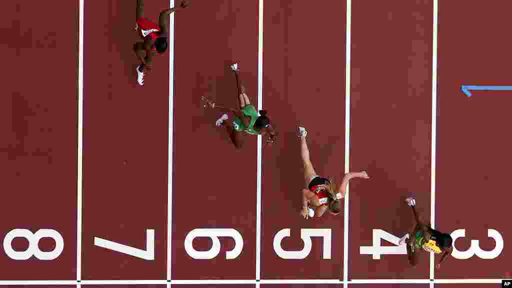 Shelly-Ann Fraser-Pryce, of Jamaica, Ajla Del Ponte, of Switzerland, Nzubechi Nwokocha, of Nigeria, and Gina Bass, of Gambia, compete during the first round of the women's 100-meter the 2020 Summer Olympics, Friday, July 30, 2021, in Tokyo. (AP Photo/Morry Gash)