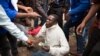 A man holds his South African identity document after being attacked by a mob in Pretoria, South Africa, Feb. 24, 2017. 
