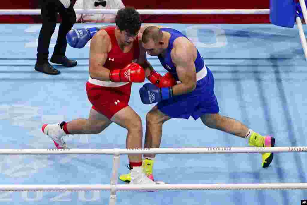 Richard Torrez Jr. from the United States, left, exchanges punches with Algeria's Chouaib Bouloudinats during their men's super heavyweight over 91-kg boxing match at the 2020 Summer Olympics, Thursday, July 29, 2021, in Tokyo, Japan. (AP Photo/Frank Franklin II)