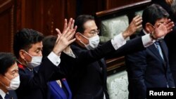 日本首相岸田文雄（中）2021年10月14日在解散眾議院後揮手打氣（路透社）