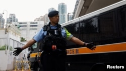 一名香港警察在一輛囚車抵達西九龍裁判法院大樓前站崗。(2024年11月19日)