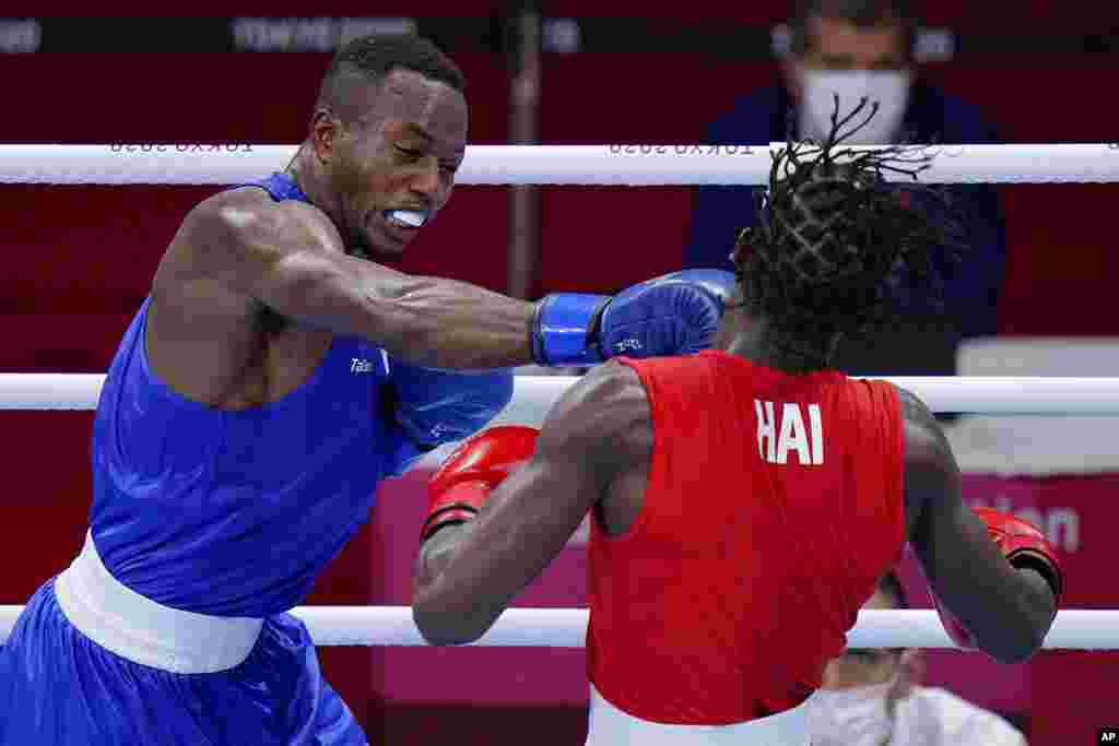 Haiti's Darrelle Valsaint Jr., right, takes a punch from David Tshama Mwenekabwe, of the Democratic Republic of the Congo, during their men's middleweight 75-kg boxing match at the 2020 Summer Olympics, Thursday, July 29, 2021, in Tokyo, Japan. (AP Photo/Frank Franklin II)
