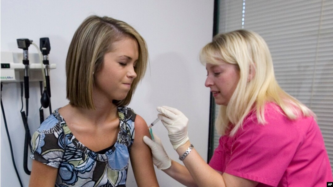 FILE - Lauren Fant, left, winces as she has the human papillomavirus (HPV) vaccine administered by nurse Stephanie Pearson at a doctor's office in Marietta, Ga., Dec. 18, 2007. 