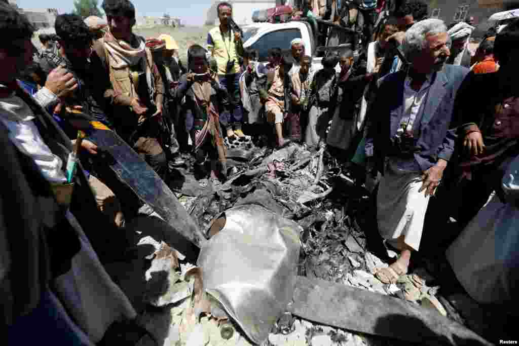 People gather around the engine of a drone aircraft which the Houthi rebels said they have downed in Sana'a, Yemen.