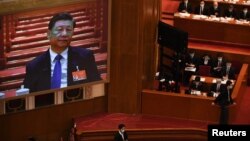 北京人大會堂舉行的全國人大年度會議大屏幕上顯示中國領導人習近平在出席會議。（2021年3月8日）