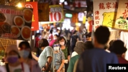 台灣台北市民眾戴著口罩逛夜市。 （2021年7月6日）