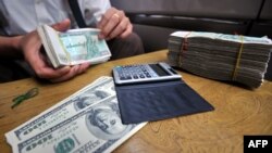 TO GO WITH Myanmar-politics-economy-forex,FOCUS by Daniel ROOK This picture taken on September 3, 2011 shows an illegal money changer exchanging Myanmar kyat bank notes into US dollars in a back alley of the country's main city and former capital Yangon. 
