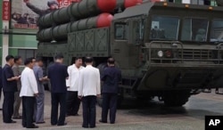 지난해 9월 8일 국방공업기업소를 방문한 김정은 북한 국무위원장이 이동식발사대(TEL) 앞에서 관계자들과 대화하고 있다.