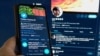 A message from the Twitter communications department confirming the hacking of co-founder and CEO Jack Dorsey's Twitter account and his postings is seen on a mobile phone held in front of Dorsey's twitter feed displayed on a computer screen in this photo 