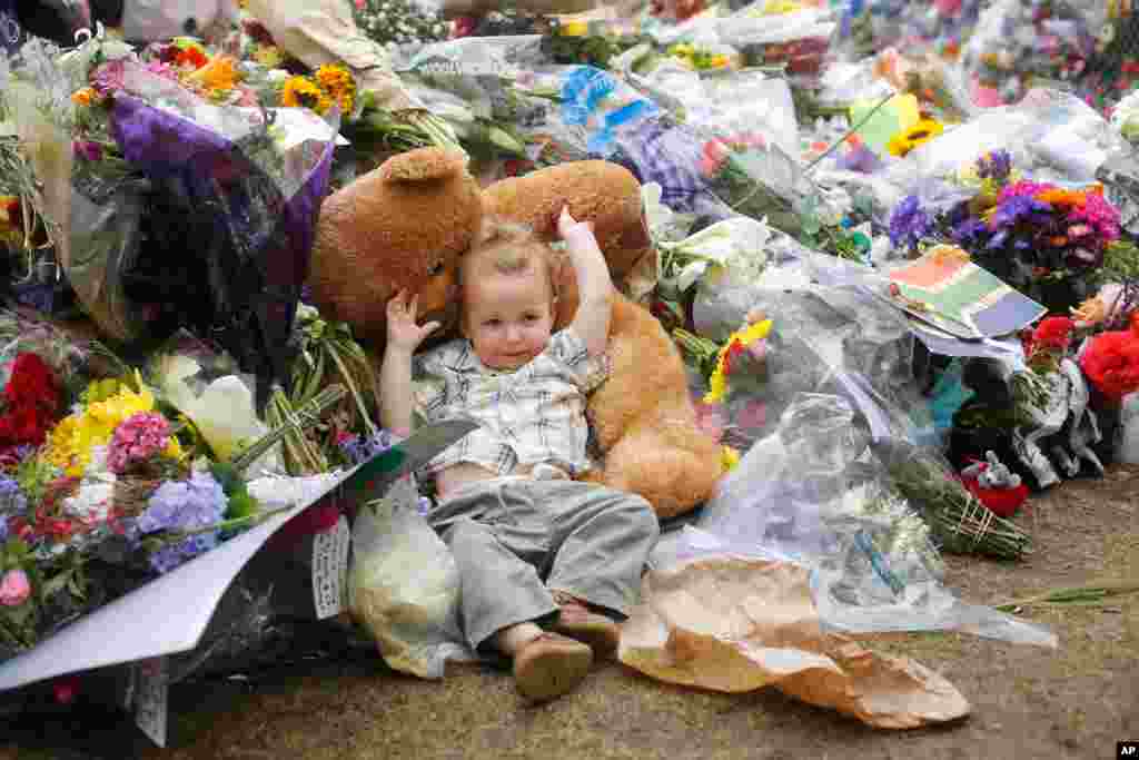 Kiran, um bebé com cerca de dois anos descansa num ursinho de peluche que entre flores à porta de casa de Nelson Mandela em Joanesburgo, Dez. 9, 2013.