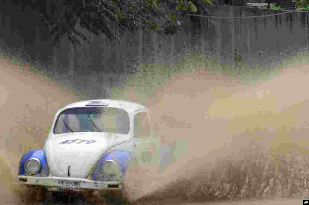 A taxi speeds along a rain flooded street in Acapulco, Guerrero state, Mexico.