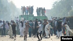 Para pendukung partai mantan Perdana Menteri Imran Khan yang dipenjara, Pakistan Tehreek-e-Insaf (PTI), melempar batu selama unjuk rasa antipemerintah di Islamabad, Pakistan, 5 Oktober 2024. (Foto: M Asim/REUTERS)