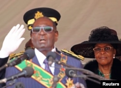 FILE - Zimbabwe President Robert Mugabe and his wife, Grace, look on during the Defense Force's 36th Anniversary celebrations in the capital Harare, Zimbabwe, Aug. 9, 2016.