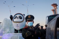 一名中國武警士兵在北京的冬奧會吉祥物前給拍照者做手勢。（2022年1月15日）