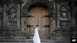 FILE - A Filipino bride arranges her gown before her wedding at a Catholic church in Manila, Philippines.
