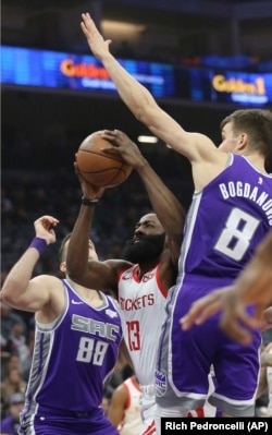 Nemanja Bjelica (levo) i Bogdan Bogdanović opokušavaju da zaustave prodor beka Hjustona Džejmsa Hardena (Foto: AP/Rich Pedroncelli)