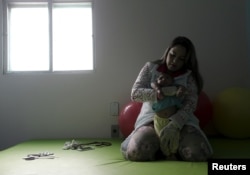 Physiotherapist Jeime Lara Leal does exercises with Lucas, 4-months old, who is Miriam Araujo's second child and born with microcephaly in Pedro I hospital in Campina Grande, Brazil, Feb. 17, 2016.