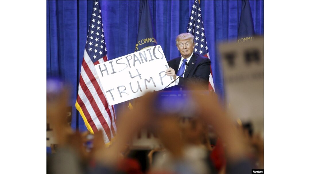 FILE - Republican U.S. presidential candidate Donald Trump holds up a sign from the audience as he speaks to supporters at a Super Tuesday campaign rally in Louisville, Kentucky, March 1, 2016.