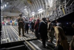 Penumpang Afghanistan menaiki C-17 Globemaster III Angkatan Udara AS selama evakuasi Afghanistan di Bandara Internasional Hamid Karzai di Kabul, Afghanistan. (Foto: via AP)