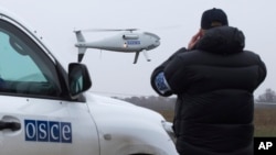 Arhiva - Pripadnik posmatračke misije OEBS-a u Ukrajini posmatra poletanje drona, tokom probnog leta u gradu Mariupol, istočna Ukrajina, 23. oktobra 2014.