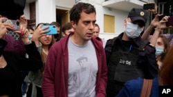 FILE - Police officers and journalists surround Roman Dobrokhotov in Moscow, July 28, 2021.