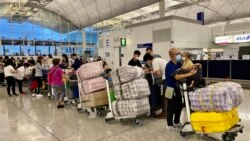 英國LOTR安排屆滿前夕，7月18日晚香港國際機場出現移居英國的人潮，他們推著堆積如山的行李，港人慣用的大型”紅白藍袋”成為機場特別的風景。（美國之音湯惠芸）