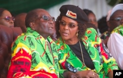 Zimbabwean President Robert Mugabe and his wife Grace follow proceedings during a youth rally in Marondera about 100 kilometers east of Harare, June, 2, 2017.