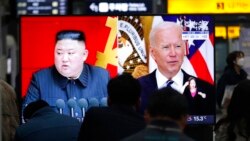 ARHIVA - Putnici na železničkoj stanici u Seulu u Južnoj Koreji gledaju TV ekran sa snimcima severnokorejskog lidera Kim Džong Una i američkog predsednika Džoa Bajdena, 26. marta 2021.