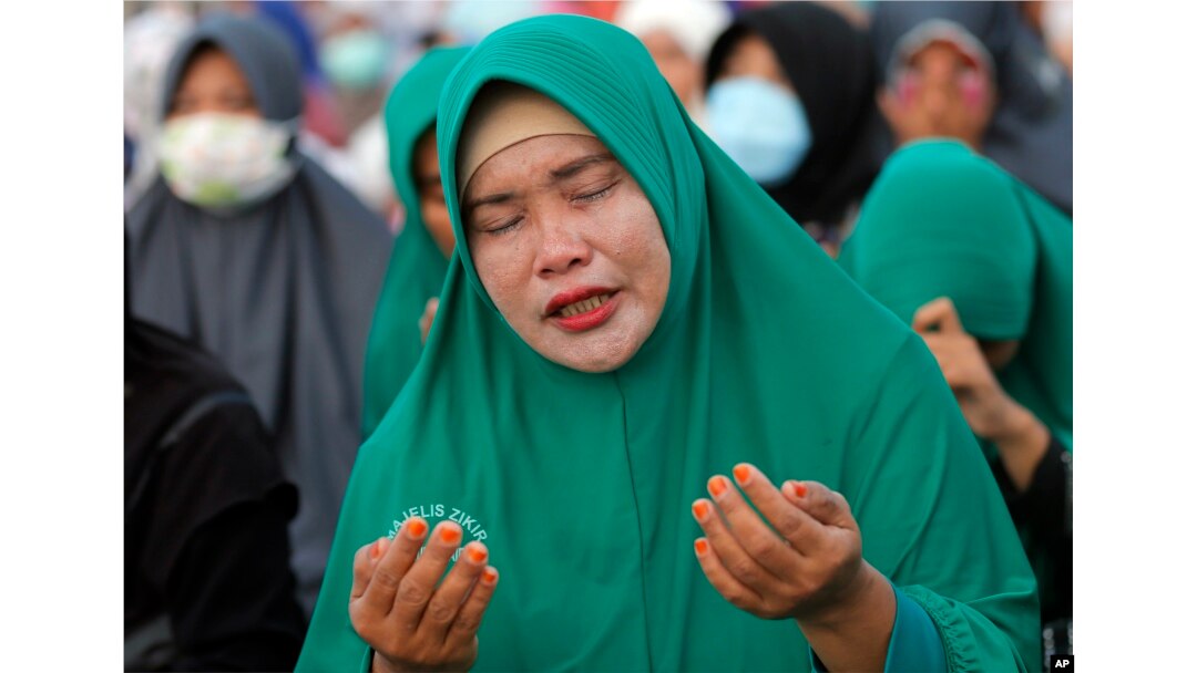 A Muslim woman prays during a special prayer for the victims of earthquake and tsunami at Talise beach in Palu, Central Sulawesi, Indonesia, Oct. 5, 2018.