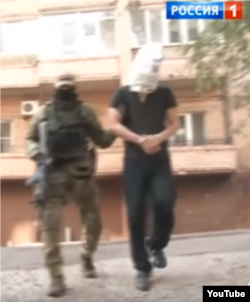 Oleksandr Pogorelov, who allegedly assassinated separatist fighter Oleksandr "Motorola" Pogorelov, led out for the caemras. (Screengrab from "News of the Week with Dmitry Kisleyov, Rossiya 1).