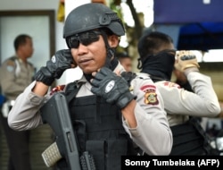 FILE - Anggota polisi khusus mempersiapkan patroli keamanan di sekitar kawasan turis di Kuta, dekat Denpasar, Bali pada 23 Maret 2017. (Sonny Tumbelaka/AP)