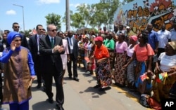 FILE - Turkey's President Recep Tayyip Erdogan and his wife, Emine Erdogan, greet local people during a ceremony in Maputo, Mozambique, Jan. 24, 2017.