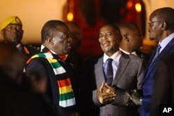 FILE: Zimbabwean President Emmerson Mnangagwa, left, arrives at Robert Mugabe International Airport in Harare, Zimbabwe, Monday, Jan. 21, 2019.