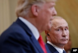 FILE - Russian President Vladimir Putin looks toward U.S. President Donald Trump as Trump speaks during their joint news conference at the Presidential Palace in Helsinki, Finland, July 16, 2018.