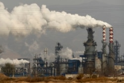 FILE - Smoke and steam rise from a coal processing plant in Hejin in central China's Shanxi Province, Nov. 28, 2019.