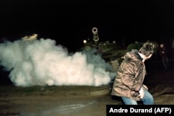 A Lithuanian demonstrator runs in front of a Soviet Red Army tank