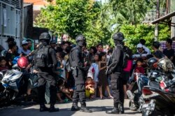 Anggota polisi anti-terorisme Densus 88 mengepung sebuah jalan ketika mereka menggeledah sebuah rumah di Surabaya, Jawa Timur, pada 19 Juni 2017, menyusul penangkapan seorang pria yang diduga terkait dengan kelompok Negara Islam (ISIS). (Foto: AFP/Juni K)