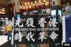 資料照：在台北車站參與支持香港行動的民眾高舉「光復香港時代革命」旗幟。 （2020年5月23日）