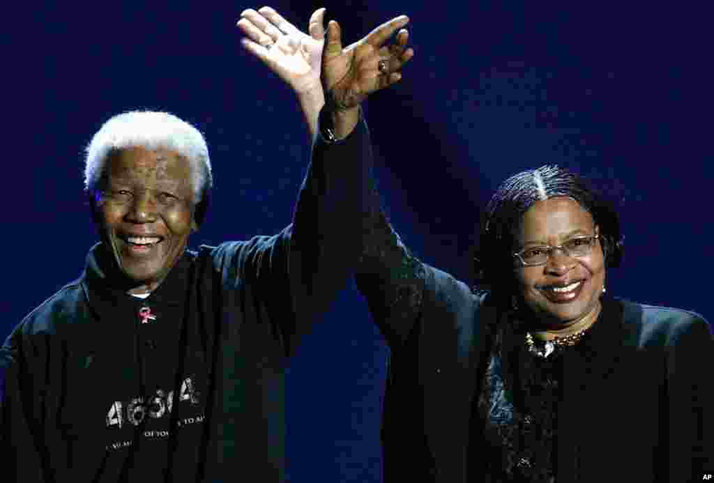 O ex-Presidente sul-africano, à esquerda, e a sua mulher, Graça Machel, cumprimentam o público de um concerto do Live 8 em Joanesburgo, África do Sul. Jul. 2, 2005.