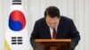 14일 용산 대통령 청사에서 윤석열 한국 대통령이 국회의 탄핵소추안 표결 가결 후 가진 대국민담화에서 고개를 숙이고 있다.