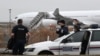 TOPSHOT - French customs officers stand next to a customs car with an Airbus A340 in the background which was grounded on the tarmac since Dec. 21 over suspected "human trafficking", at the Vatry airport, north-eastern France on Dec. 25, 2023.