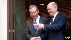 ဂျာမန်ဝန်ကြီးချုပ် Olaf Scholz နှင့် လက်ဆွဲနှုတ်ဆက်နေသည့် တရုတ်နိုင်ငံခြားရေးဝန်ကြီး Wang Yi။ (၁၅ ဖေဖော်ဝါရီ ၂၀၂၅)​ (မှတ်တမ်းဓာတ်ပုံ)
