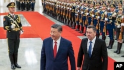 Chinese President Xi Jinping, center, walks with Kyrgyzstan's President Sadyr Japarov during the welcome ceremony at the Great Hall of the People in Beijing, China, Feb. 5, 2025.