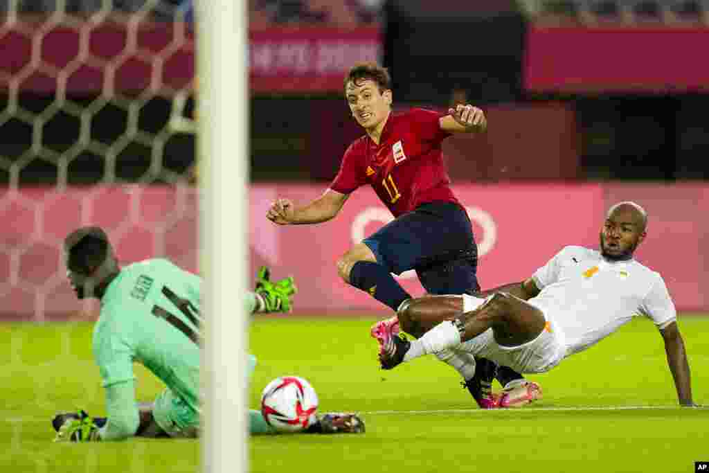Spain's Mikel Oyarzabal takes a shot as Ivory Coast's Kouadio-Yves Dabila fails to block in a men's quarterfinal soccer match at the 2020 Summer Olympics, Saturday, July 31, 2021, in Rifu, Japan, Tokyo. (AP Photo/Andre Penner)