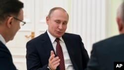 Russian President Vladimir Putin gestures as he speaks during a meeting with opposition candidates who ran against him in the presidential election, at the Kremlin in Moscow, Russia, March 19, 2018.