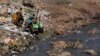 FILE - Workers dump effluent from pit latrines from the Korogocho slum of Nairobi, Kenya into a local water course.