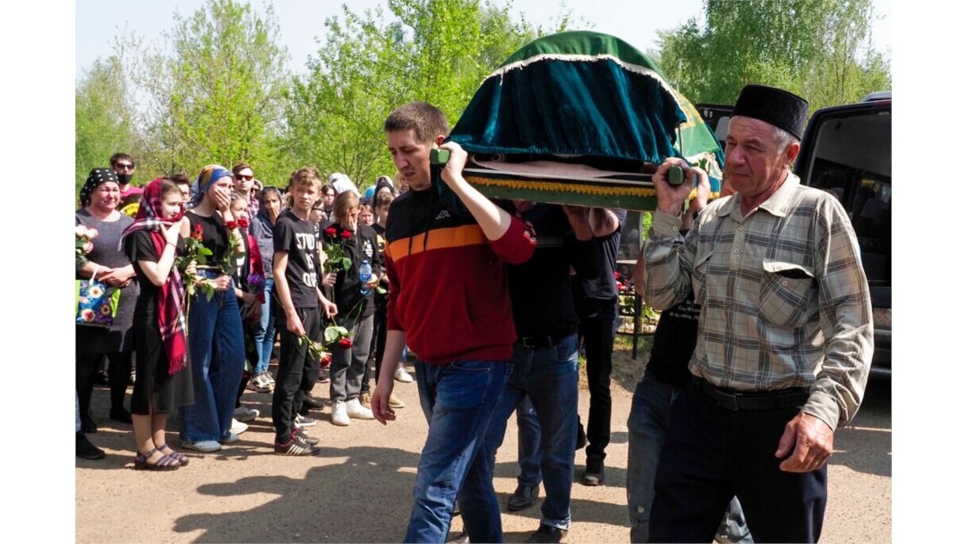 Men carry a coffin with the body of Elvira Ignatieva, a teacher who was killed in a shooting at a school on Tuesday, in Kazan, Russia, May 12, 2021.