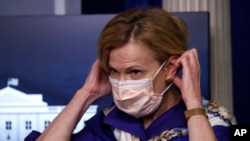 Dr. Deborah Birx, White House coronavirus response coordinator, puts on a face mask after speaking with reporters about the coronavirus in the James Brady Briefing Room of the White House, Friday, May 22, 2020, in Washington. (AP Photo/Alex Brandon)