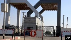 Pripadnici palestinskih bezbednosnih snaga i civili sede ispred zatvorenog prelaza Rafa, na granici sa Izraelom, 17. avgusta 2018.