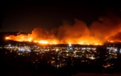 FILE - In this Oct. 31, 2019, file photo, smoke from a wildfire known as the Maria Fire billows above Santa Paula, Calif.